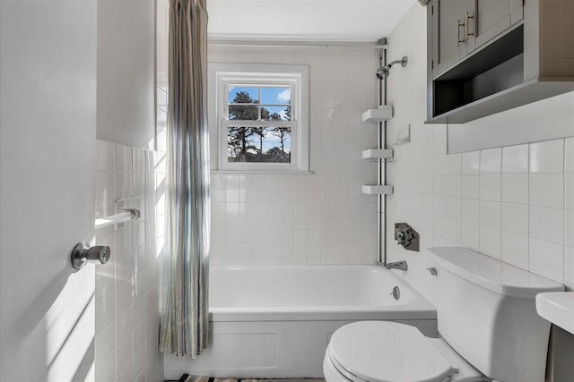 bathroom featuring tile walls, shower / tub combo, and toilet