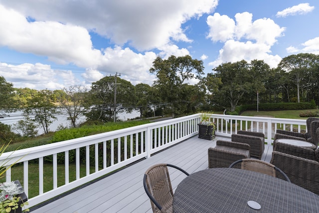 deck with a lawn and a water view