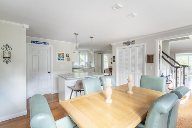 dining area featuring a healthy amount of sunlight, crown molding, and wood-type flooring