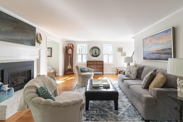 living room featuring light hardwood / wood-style flooring, a brick fireplace, and ornamental molding