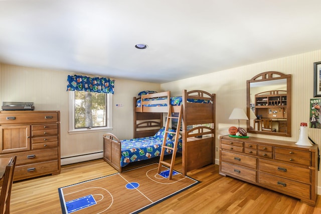 bedroom featuring light wood finished floors and baseboard heating