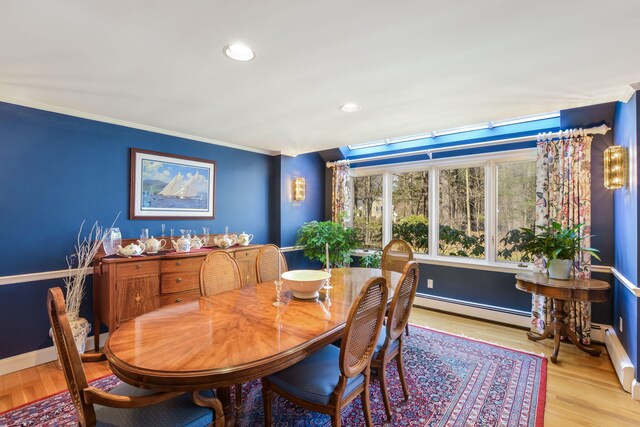 sitting room with crown molding, wood finished floors, visible vents, and baseboards