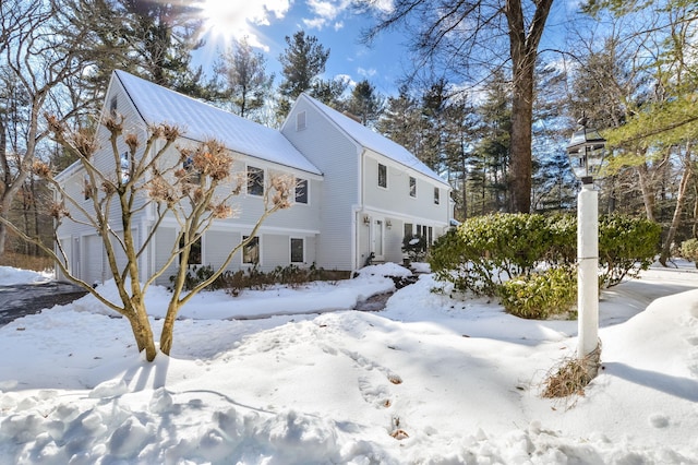 snow covered property with a garage