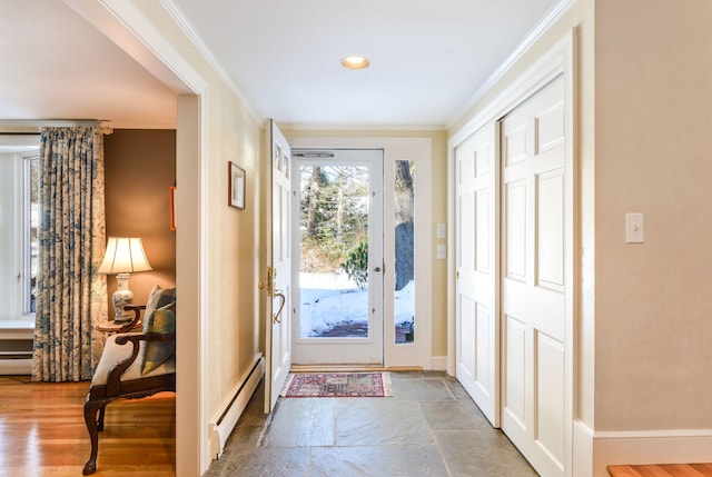 doorway to outside with stone tile flooring, baseboards, a baseboard heating unit, and crown molding