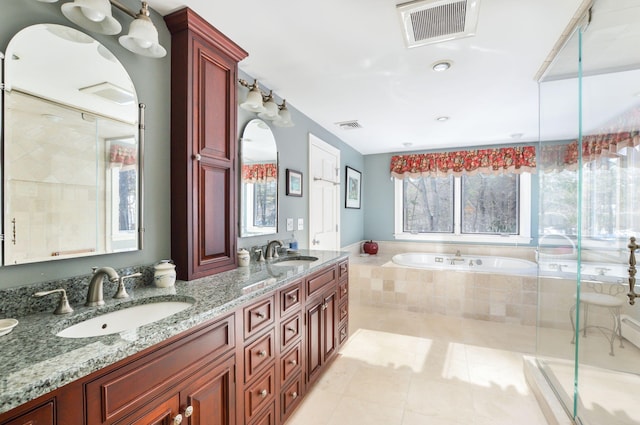 bathroom with a garden tub, visible vents, and a sink