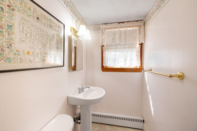 19 Anthony Rd, West Yarmouth, MA 02673 - half bathroom featuring a baseboard heating unit, toilet, baseboards, and a sink
