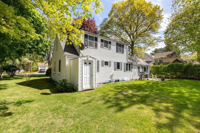 19 Anthony Rd, West Yarmouth, MA 02673 - rear view of house featuring a yard, a patio, and roof with shingles