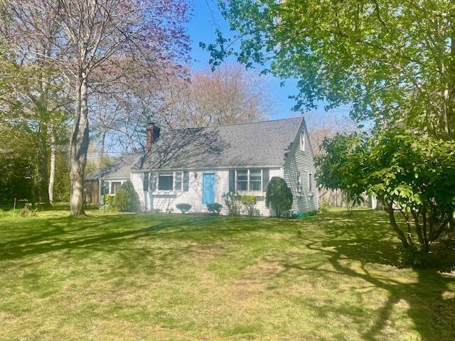 view of front of home featuring a chimney and a front lawn