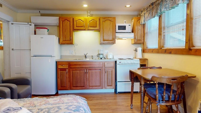 kitchen featuring extractor fan, light countertops, white appliances, light wood-style flooring, and ornamental molding