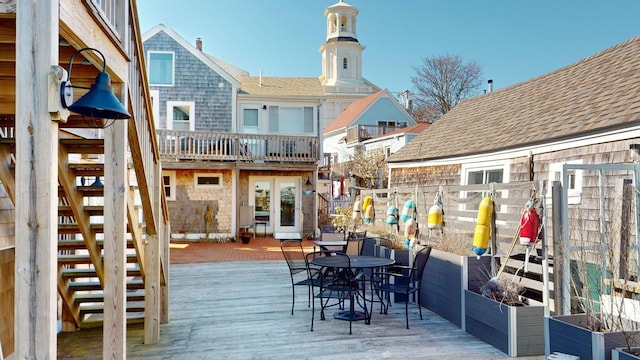 wooden deck with outdoor dining area, stairs, and french doors