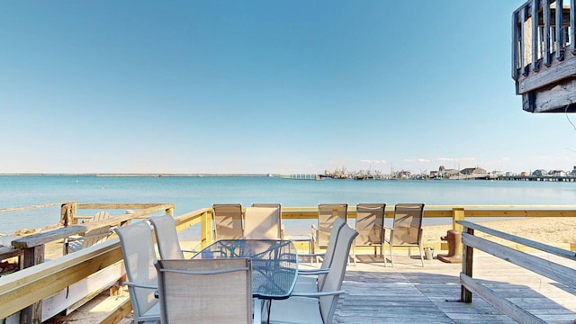 wooden deck featuring outdoor dining area and a water view