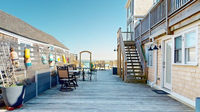 deck with outdoor dining area and stairway