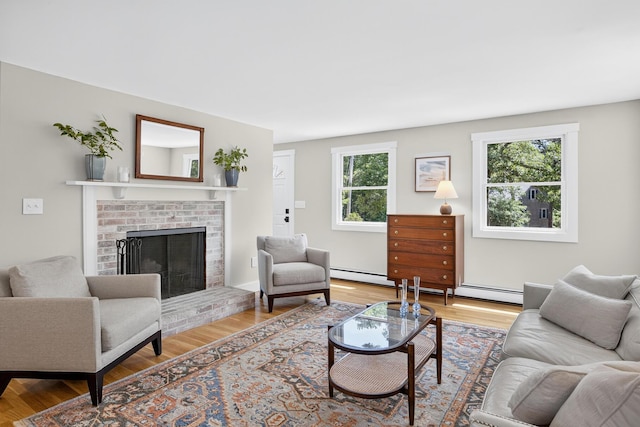44 Squirrel, Eastham, MA 02642 - living room featuring wood finished floors, a brick fireplace, a baseboard heating unit, and baseboard heating