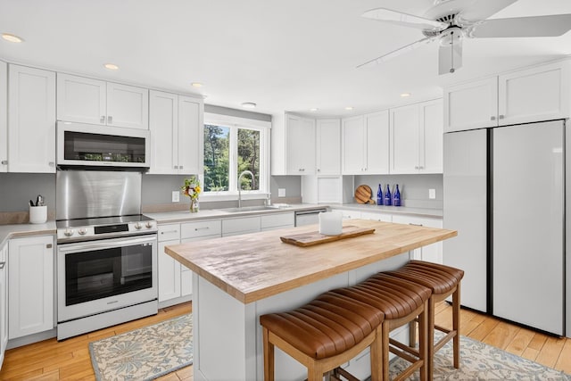 44 Squirrel, Eastham, MA 02642 - kitchen with white appliances, light countertops, light wood finished floors, a breakfast bar area, and recessed lighting