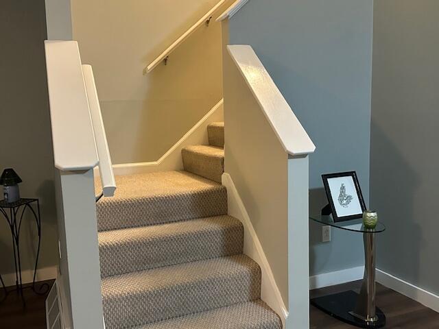 stairs with wood finished floors and baseboards
