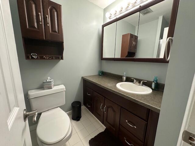 half bath featuring toilet, tile patterned floors, and vanity