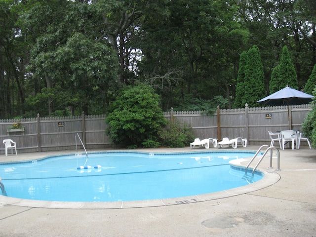 pool featuring fence and a patio area