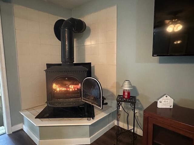 details with wood finished floors, a wood stove, and baseboards