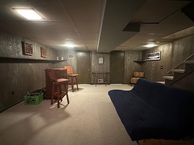 interior space featuring stairs, carpet flooring, and a drop ceiling