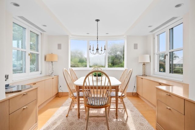 dining room with light wood-type flooring and a chandelier