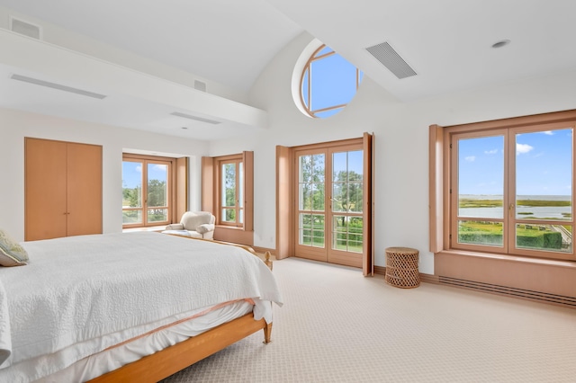 carpeted bedroom with multiple windows, a water view, vaulted ceiling, and access to outside