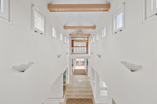 staircase with high vaulted ceiling and beam ceiling