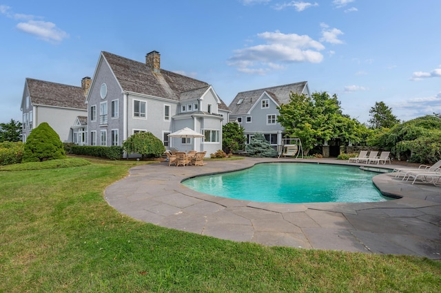 view of pool with a lawn and a patio