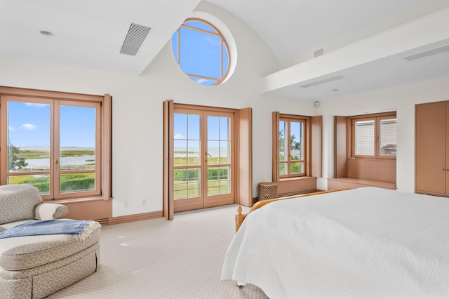 carpeted bedroom featuring access to exterior, a water view, and lofted ceiling