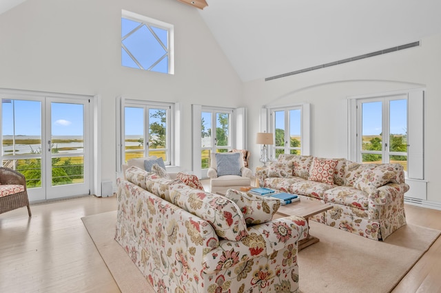 living room with high vaulted ceiling, beamed ceiling, and light hardwood / wood-style floors