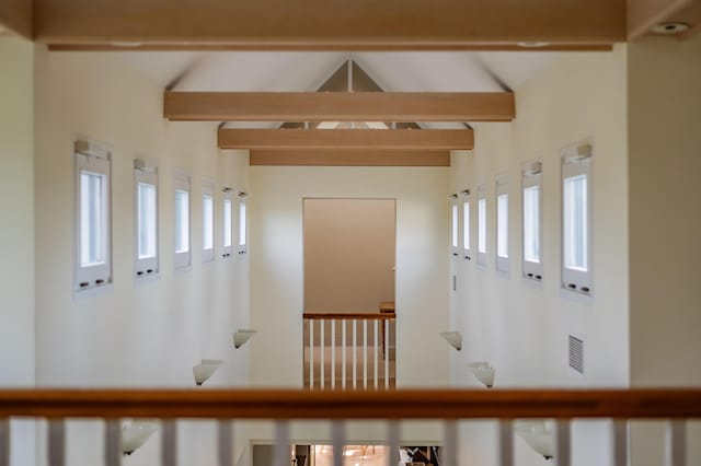 hallway featuring lofted ceiling with beams