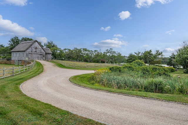 surrounding community with an outdoor structure, a yard, and a rural view