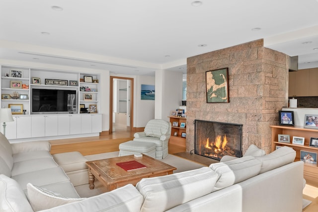 living room featuring a tile fireplace and light wood-type flooring