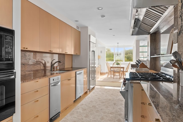 kitchen with sink, decorative light fixtures, dark stone counters, black appliances, and an inviting chandelier