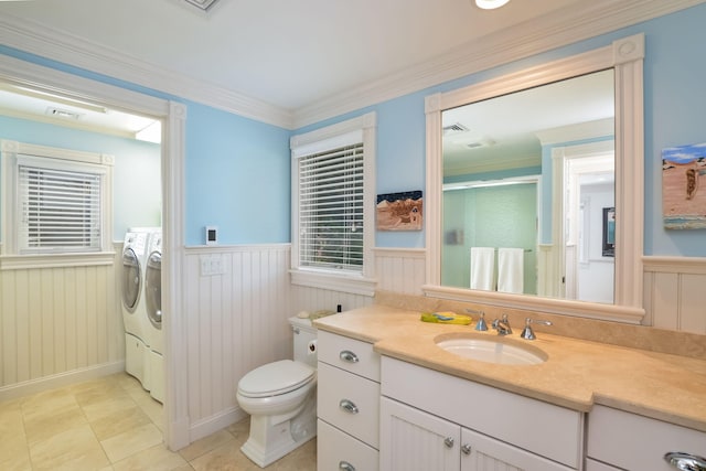 bathroom with washing machine and dryer, tile patterned flooring, vanity, toilet, and ornamental molding