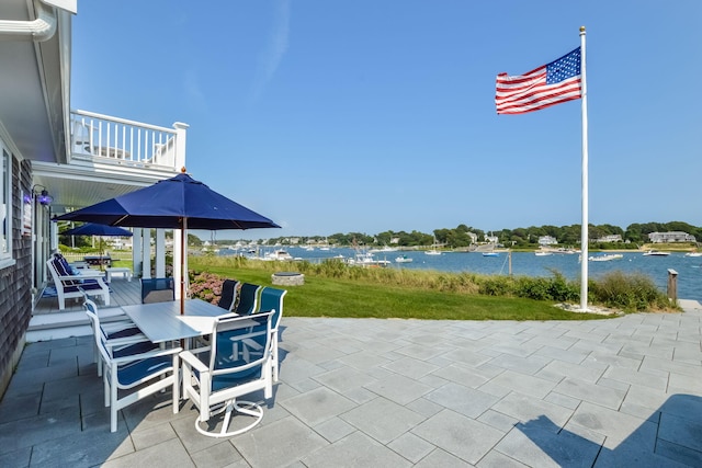 view of patio featuring a balcony and a water view