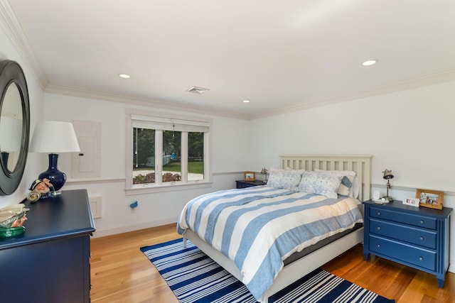 bedroom with light wood-type flooring and ornamental molding