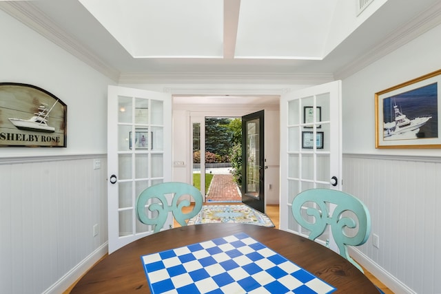 dining space with hardwood / wood-style flooring, crown molding, and french doors