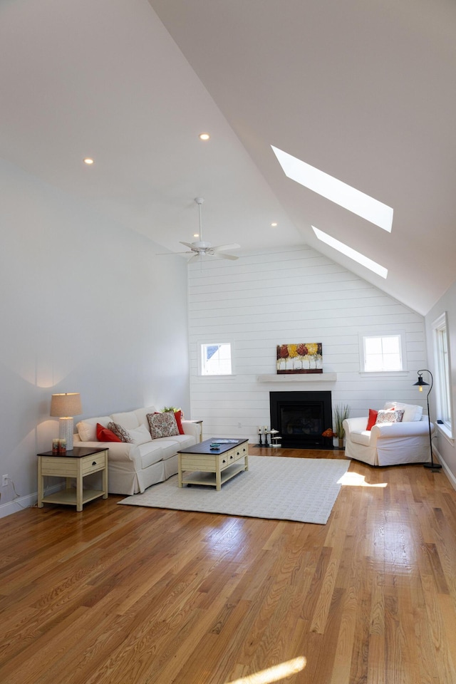 55 Blue Castle Dr, Mashpee, MA 02649 - living area featuring a skylight, lofted ceiling, wood finished floors, a fireplace, and recessed lighting