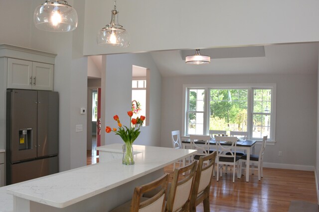 55 Blue Castle Dr, Mashpee, MA 02649 - kitchen with stainless steel fridge, light wood-style flooring, light stone countertops, pendant lighting, and baseboards