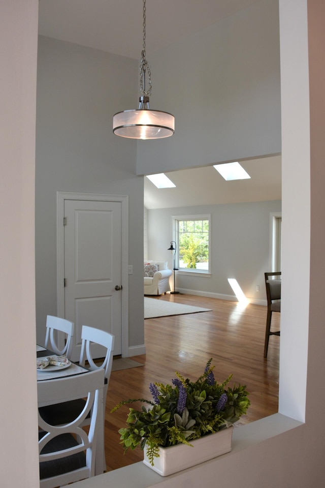 55 Blue Castle Dr, Mashpee, MA 02649 - dining space featuring wood finished floors, baseboards, a high ceiling, and a skylight