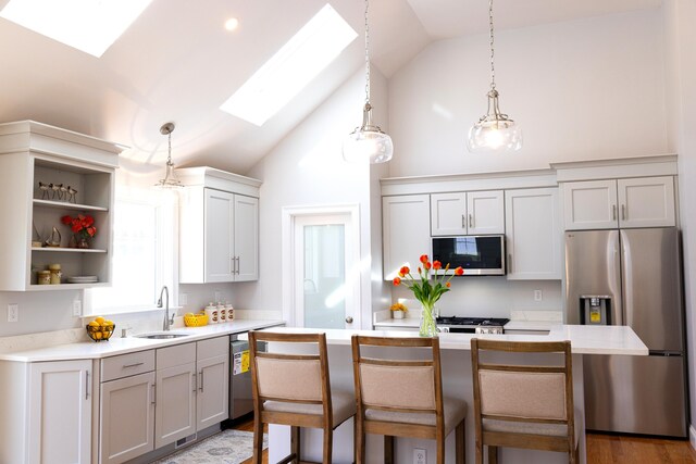 55 Blue Castle Dr, Mashpee, MA 02649 - kitchen featuring stainless steel appliances, a sink, a skylight, light countertops, and gray cabinets