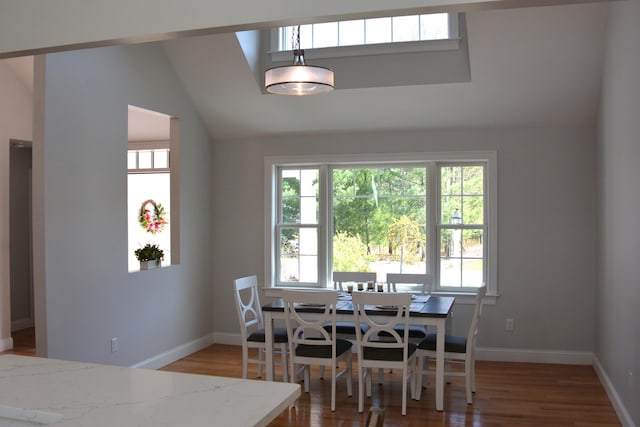 55 Blue Castle Dr, Mashpee, MA 02649 - dining room with healthy amount of natural light, wood finished floors, vaulted ceiling, and baseboards