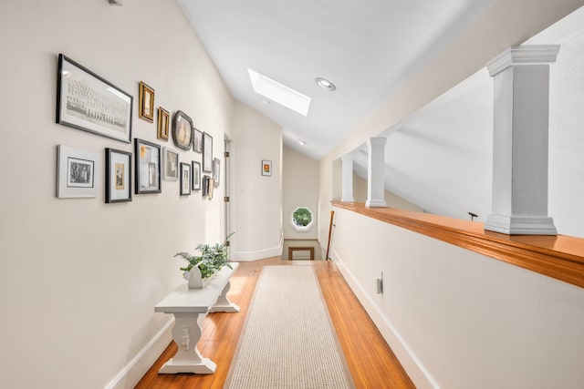 5 Putnam Ave, Cotuit, MA 02635 - hallway with decorative columns, wood finished floors, a skylight, vaulted ceiling, and recessed lighting