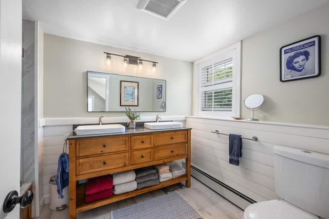 5 Putnam Ave, Cotuit, MA 02635 - bathroom with baseboard heating, wood finished floors, double vanity, and a wainscoted wall