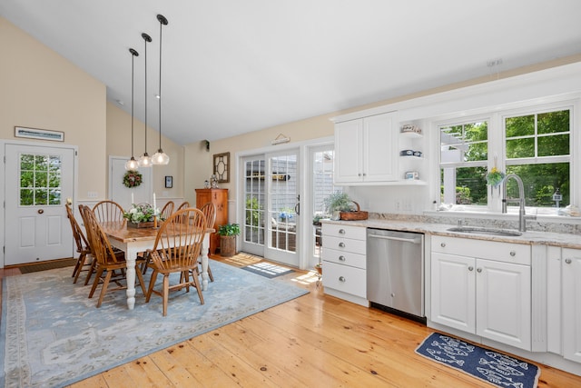 5 Putnam Ave, Cotuit, MA 02635 - kitchen with stainless steel dishwasher, light wood-style flooring, white cabinets, light stone counters, and high vaulted ceiling