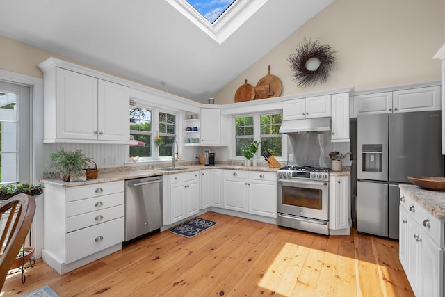 5 Putnam Ave, Cotuit, MA 02635 - kitchen featuring appliances with stainless steel finishes, light wood-type flooring, white cabinetry, a skylight, and under cabinet range hood