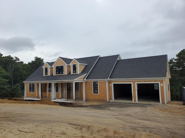 new england style home with a garage and a porch