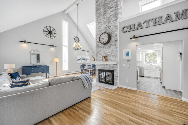 46 Juniper Ln W, South Chatham, MA 02659 - living room with high vaulted ceiling, an inviting chandelier, light wood-style flooring, and a baseboard radiator