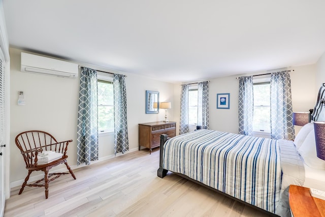 46 Juniper Ln W, South Chatham, MA 02659 - bedroom with light wood-style floors, baseboards, multiple windows, and a wall mounted AC