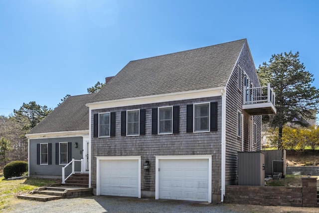 46 Juniper Ln W, South Chatham, MA 02659 - tri-level home with driveway, a shingled roof, a balcony, and a garage
